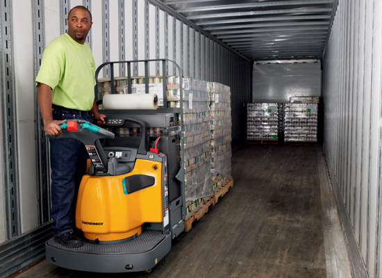 Male using a Jungheinrich ECR 327/336 electric walkie end rider pallet jack to load a semi-truck.