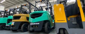 Row of teal and yellow used forklifts